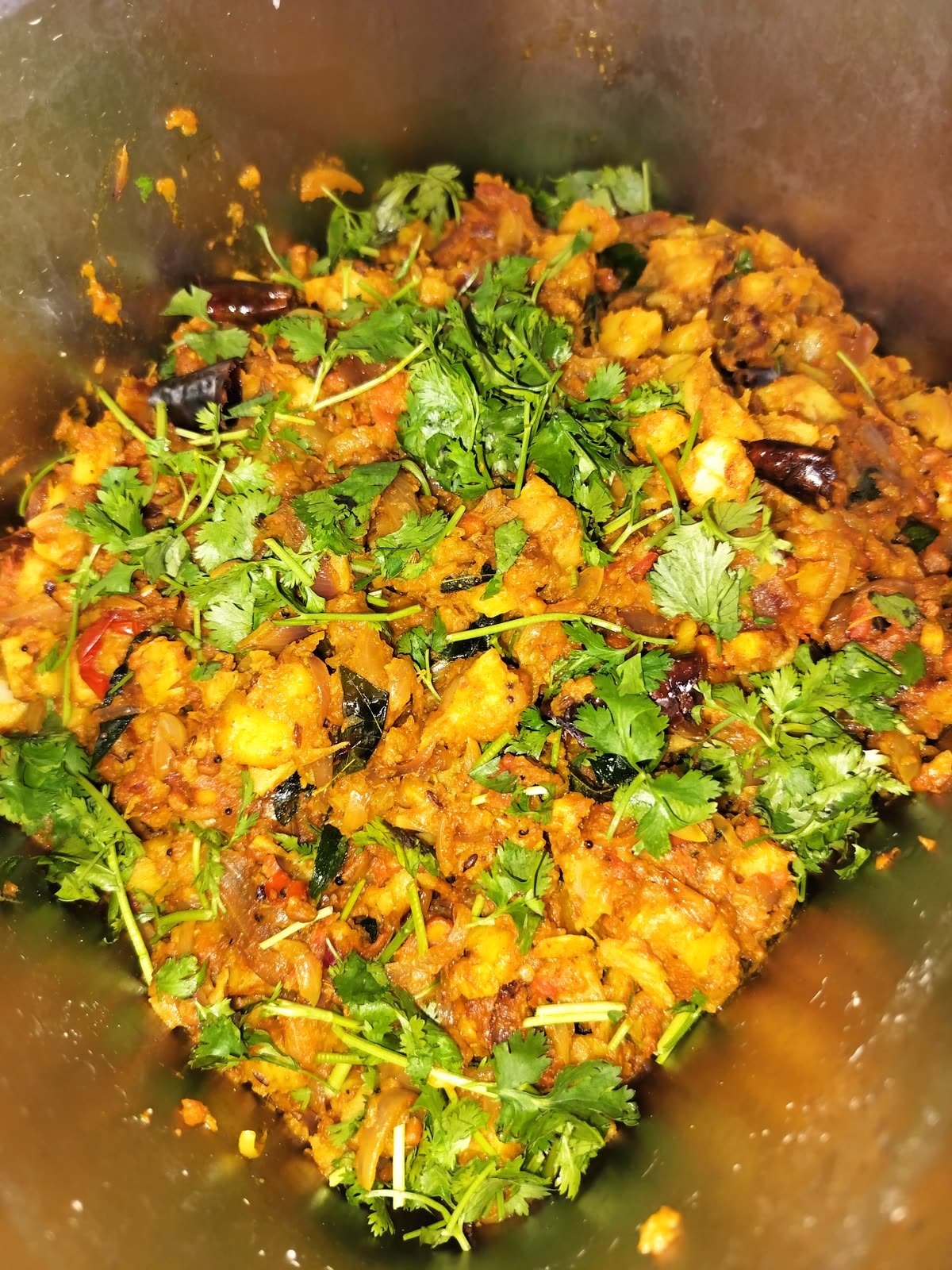 A vegetable side dish topped with fresh coriander