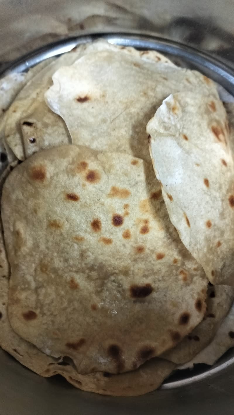Fresh chapatis stacked in a steel vessel